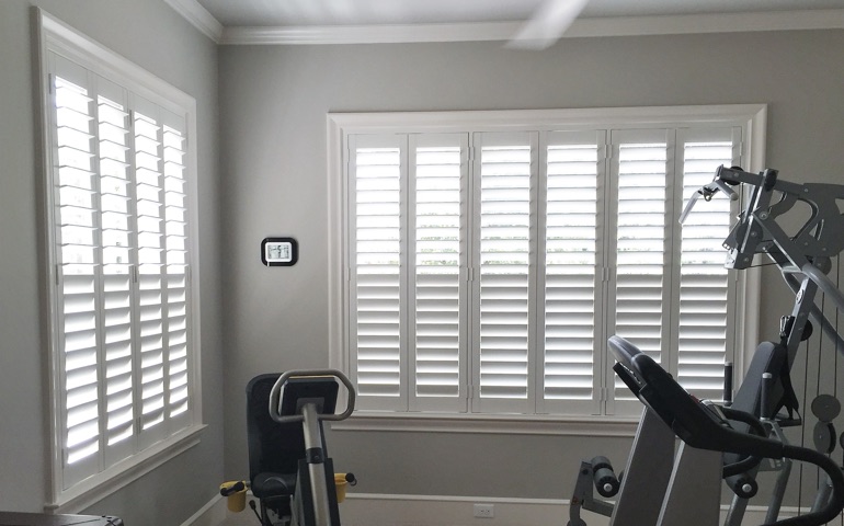 Destin exercise room with shuttered windows.
